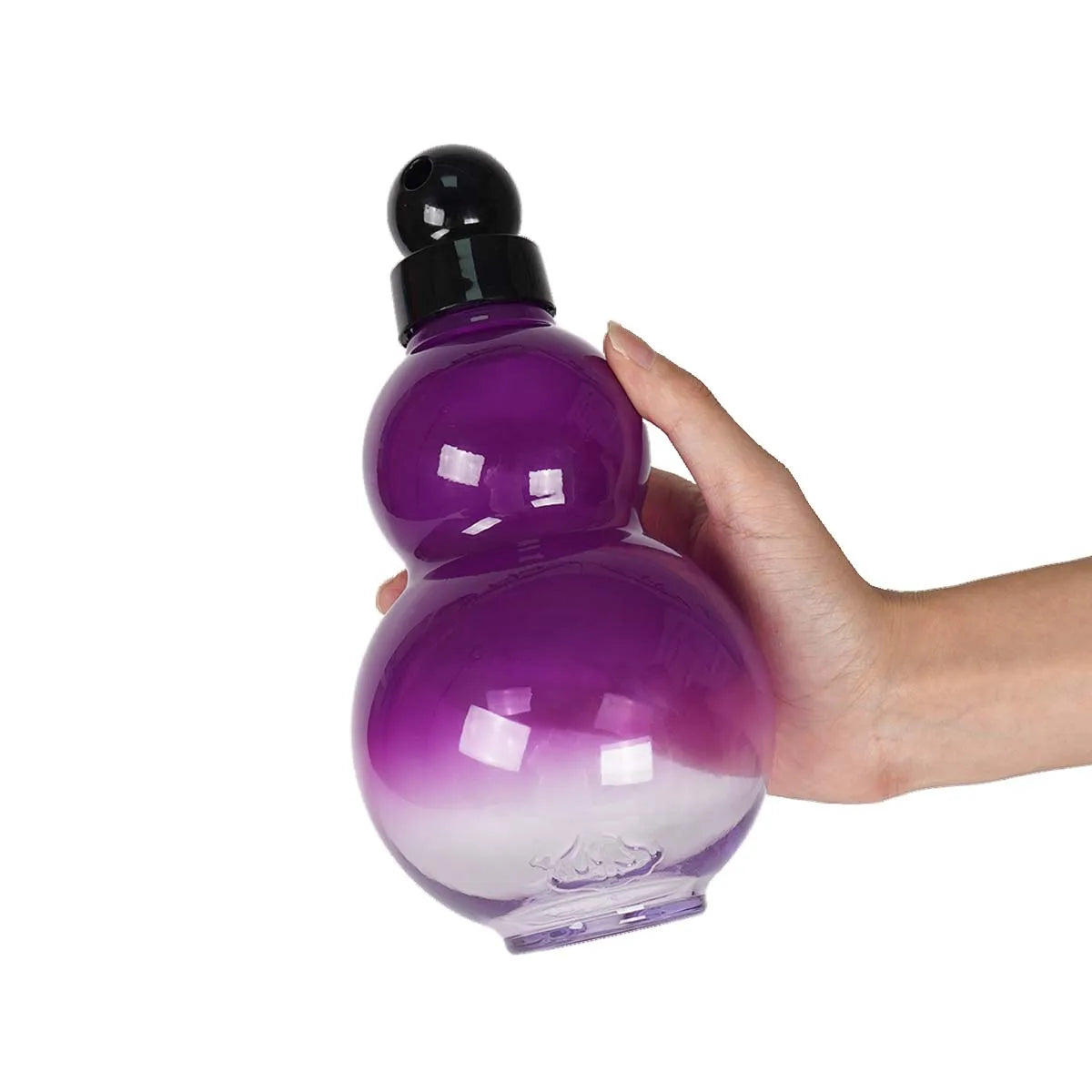 Eine Hand hält eine lila, gurfförmige Sportflasche mit schwarzem Deckel.