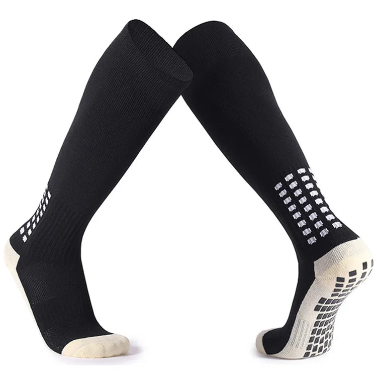 A pair of black and white long football training socks displayed against a white background.