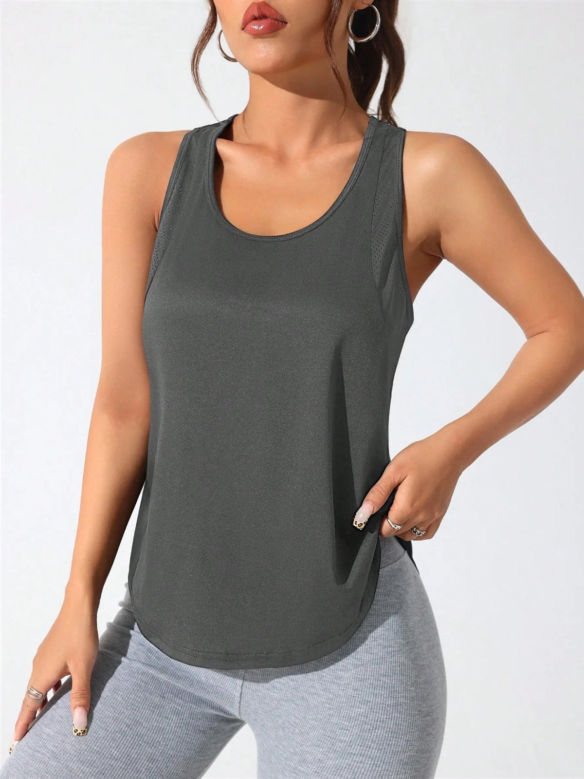 A woman wearing a dark gray athletic vest and light gray pants, posing for a product photo.