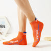 A close-up of an orange breathable men's athletic sock worn on a foot.
