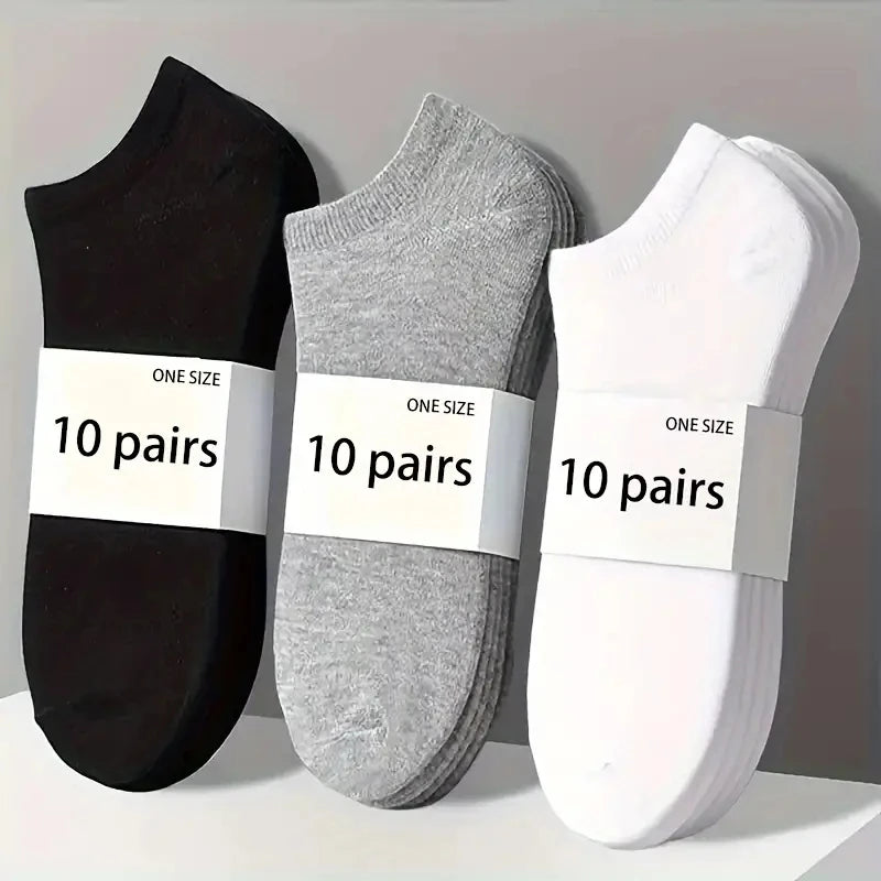 Three pairs of comfort fit ankle socks in black, gray, and white are displayed on a light surface.