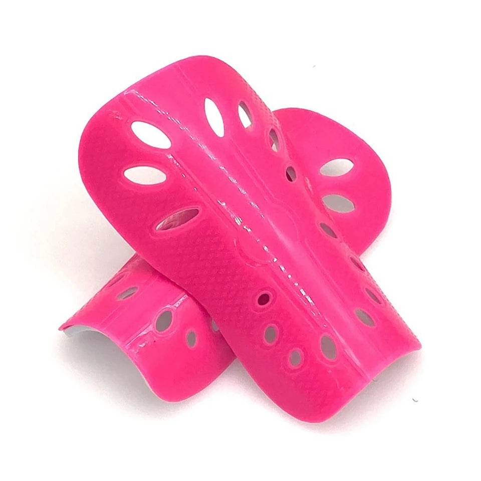 A bright pink adjustable EVA soccer shin guard with multiple perforations.