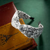 Una diadema de tela con estampado blanco está apoyada sobre una pila de libros viejos.