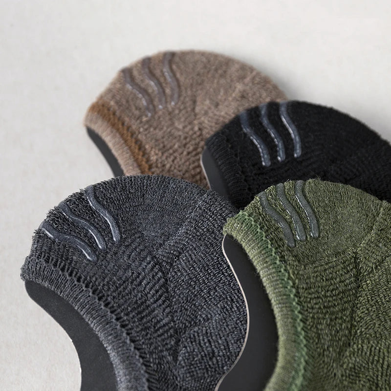 A close-up of several pairs of men's cotton crew socks in various earthy and dark tones.