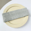 A stack of five gray elastic hairbands resting on a light beige plate.