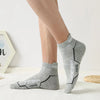 Gray athletic socks worn on a person's foot, showing the design and texture.