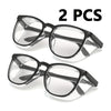 Dos pares de gafas de seguridad transparentes con monturas negras sobre fondo blanco.