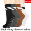 Cuatro pares de calcetines de yoga y pilates sin deslizamiento para mujer en negro, gris, marrón y blanco.