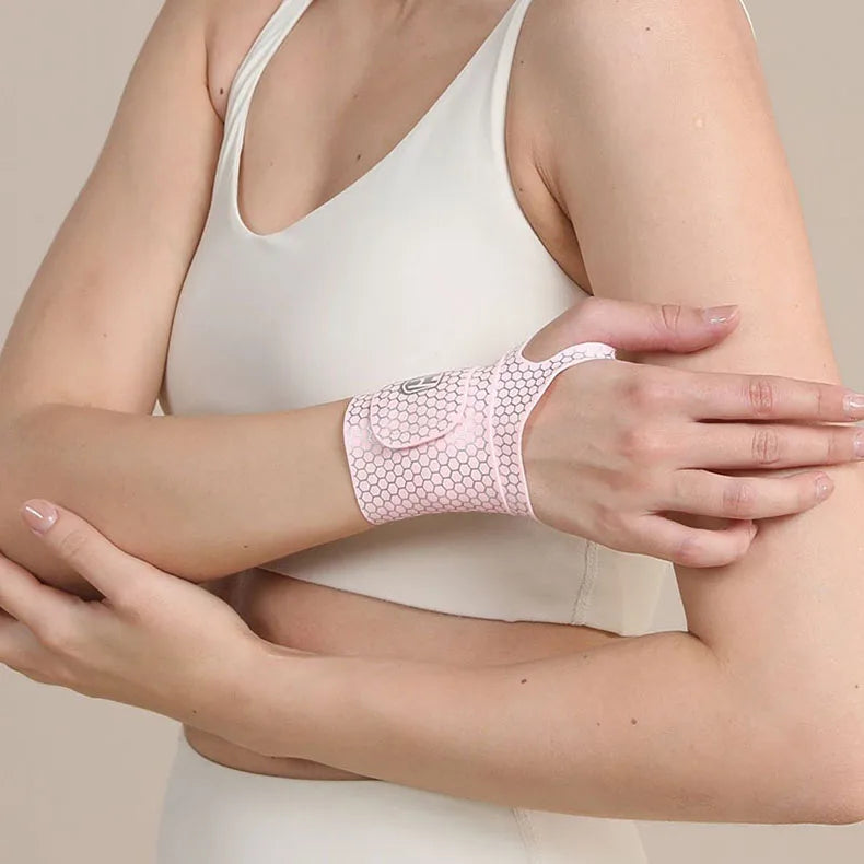 A woman wearing a white top is demonstrating an ultra-thin pink spandex wrist guard for joint support.