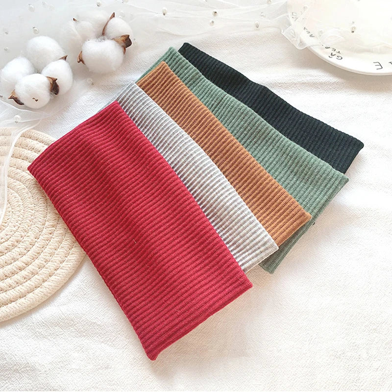 A pack of five colored elastic hairbands for fitness and yoga displayed on a white fabric.