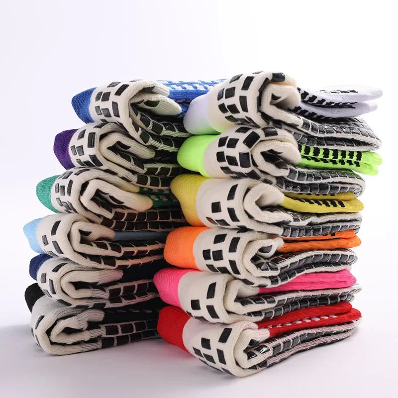 A stack of performance sports grip socks in various colors and patterns.