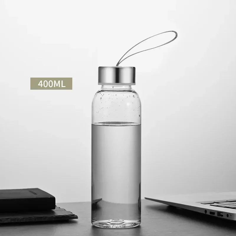 Una botella de agua deportiva transparente con tapa plateada y una pajita delgada, sobre una superficie oscura.
