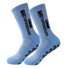A pair of light blue anti-slip performance sports socks with black text and grip dots.