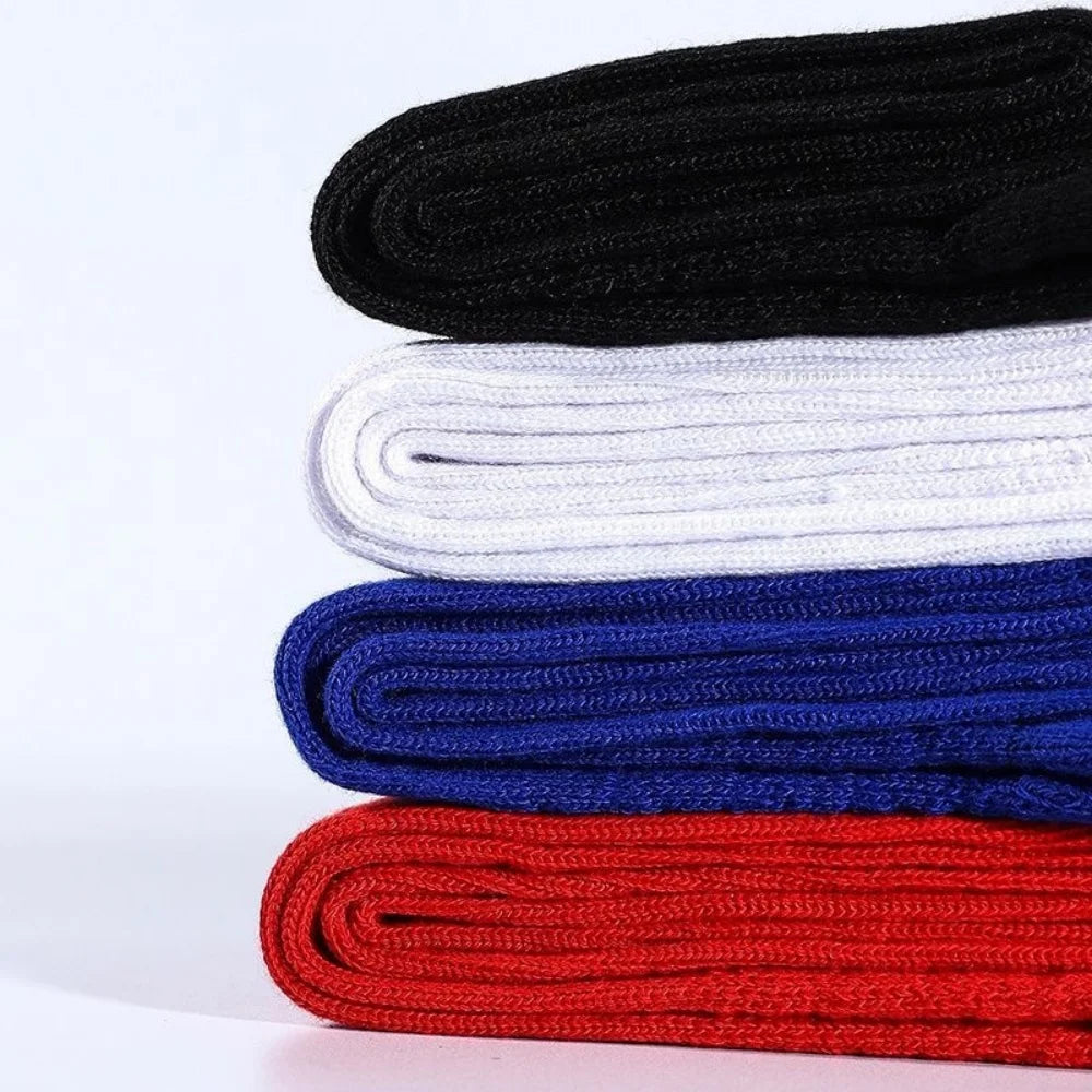 A stack of knee-high sports socks in black, white, blue, and red colors.