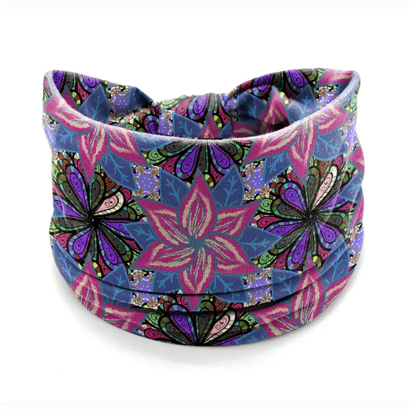 A colorful bohemian stretch cotton headband featuring a vibrant floral pattern in shades of purple, pink, and blue.