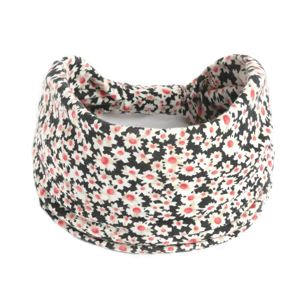 Un bandeau à cheveux large avec motif floral noir et blanc.