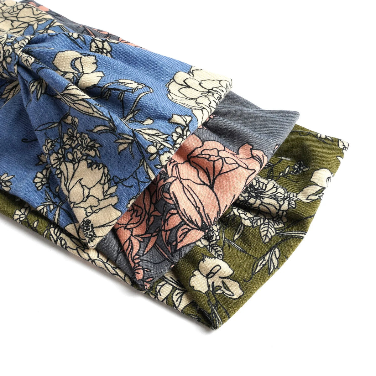 A stack of bohemian cotton stretch headbands in floral patterns featuring blue, pink, and olive green tones.