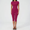 A woman wearing a magenta women's premium fitness tracksuit top and leggings.