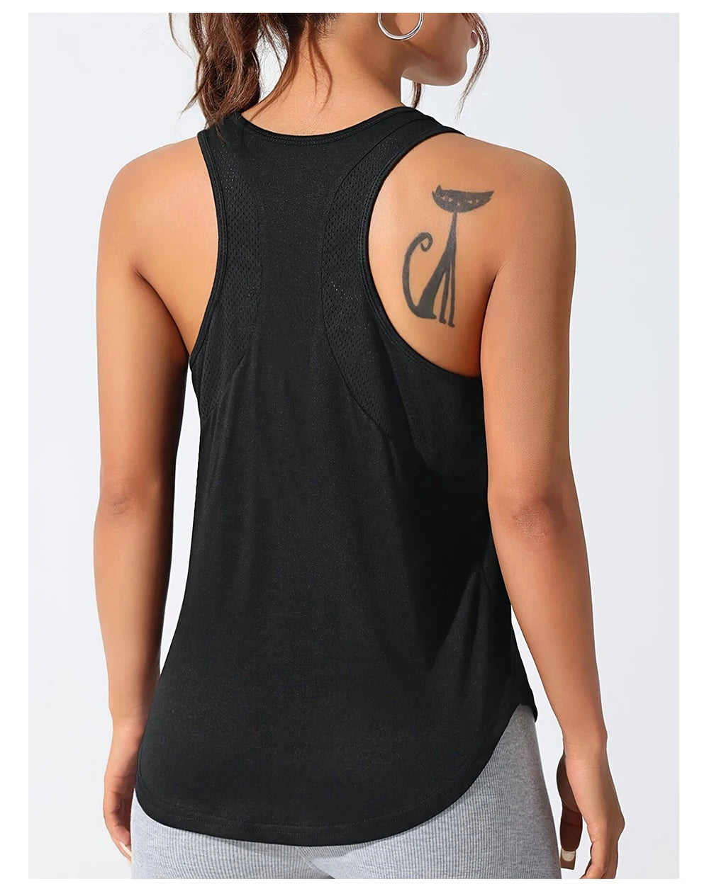 A woman wearing a black breathable sport tank top with a graphic design on the shoulder.