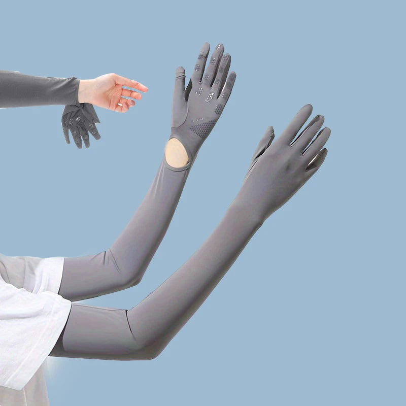 Una mano vistiendo una manga elástica protectora UV gris extiende su brazo contra un fondo azul claro.