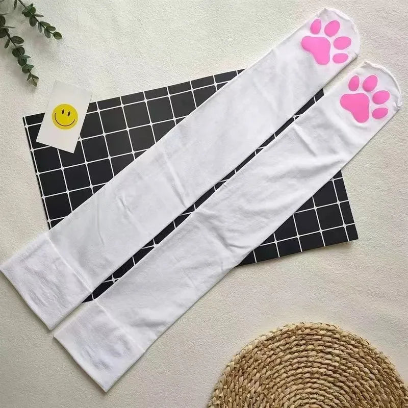 White thigh high socks with pink paw prints displayed on a black grid background.
