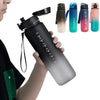 A hand holds a black sports water bottle alongside several colored versions of the Spirit brand water bottles.