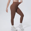 A model wearing high-waisted brown quick-drying yoga leggings and white sneakers.