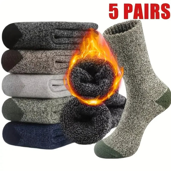 Five pairs of dark gray merino wool hiking socks displayed next to a bundle of glowing fire.
