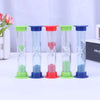 A set of six colorful hourglasses with green, blue, and red tops and glass bodies arranged in a row.