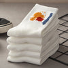 A stack of white breathable cotton socks with orange and blue designs resting on a black wire grid.
