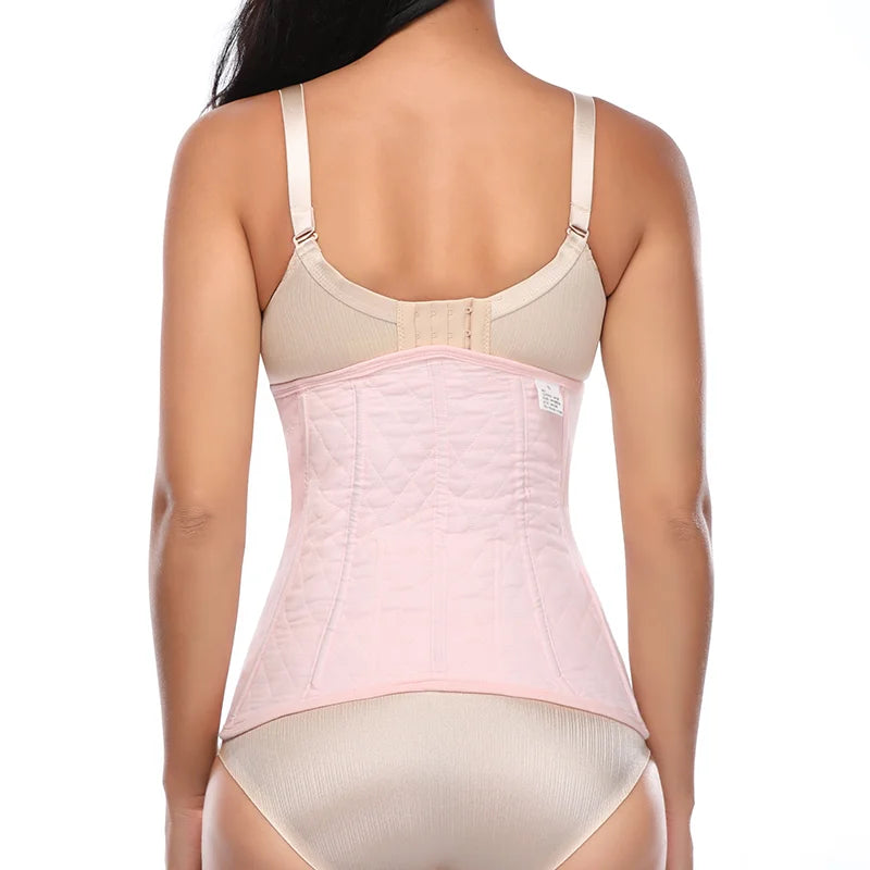 Eine Frau trägt einen beige-rosa Postpartum-Erholungsbinder für den Bauch.