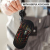 A hand is holding a black silicone pouch with a spider web design attached to a keychain.