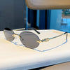 Rimless oval gradient sunglasses with gold-toned metal frame resting on a white surface.