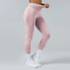 A model wearing light pink high-waist yoga leggings and white socks, standing against a light gray background.
