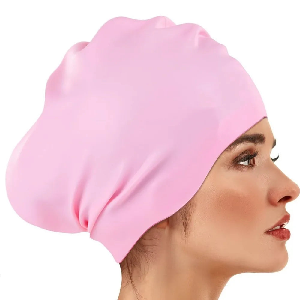 A pink silicone swim cap is shown on a woman's head, highlighting its smooth texture and fit.