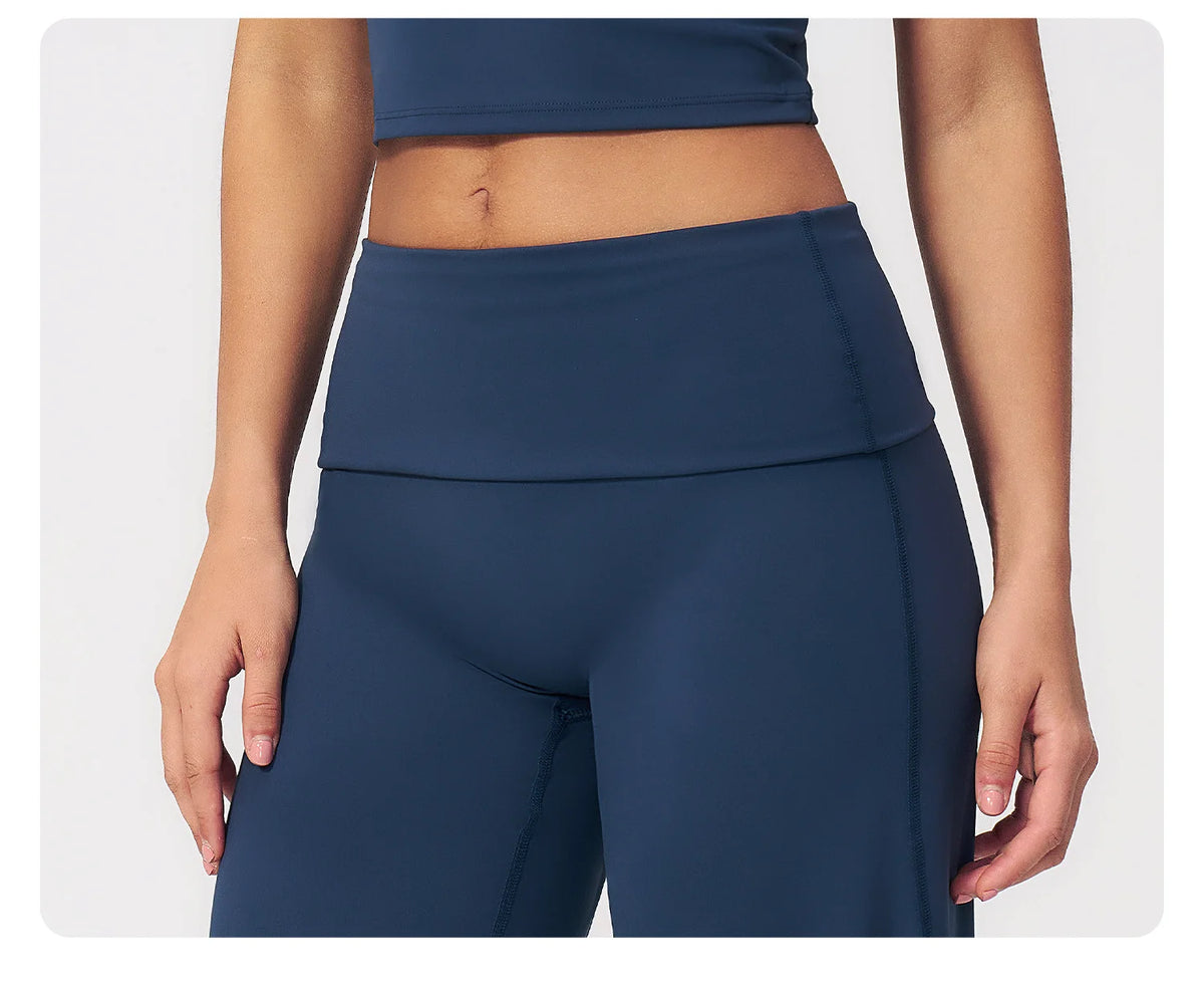 A model wearing dark blue flared high-waist yoga and fitness pants.