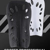 A pair of black and white soccer leg warmers or shin guards displayed against a dark background.