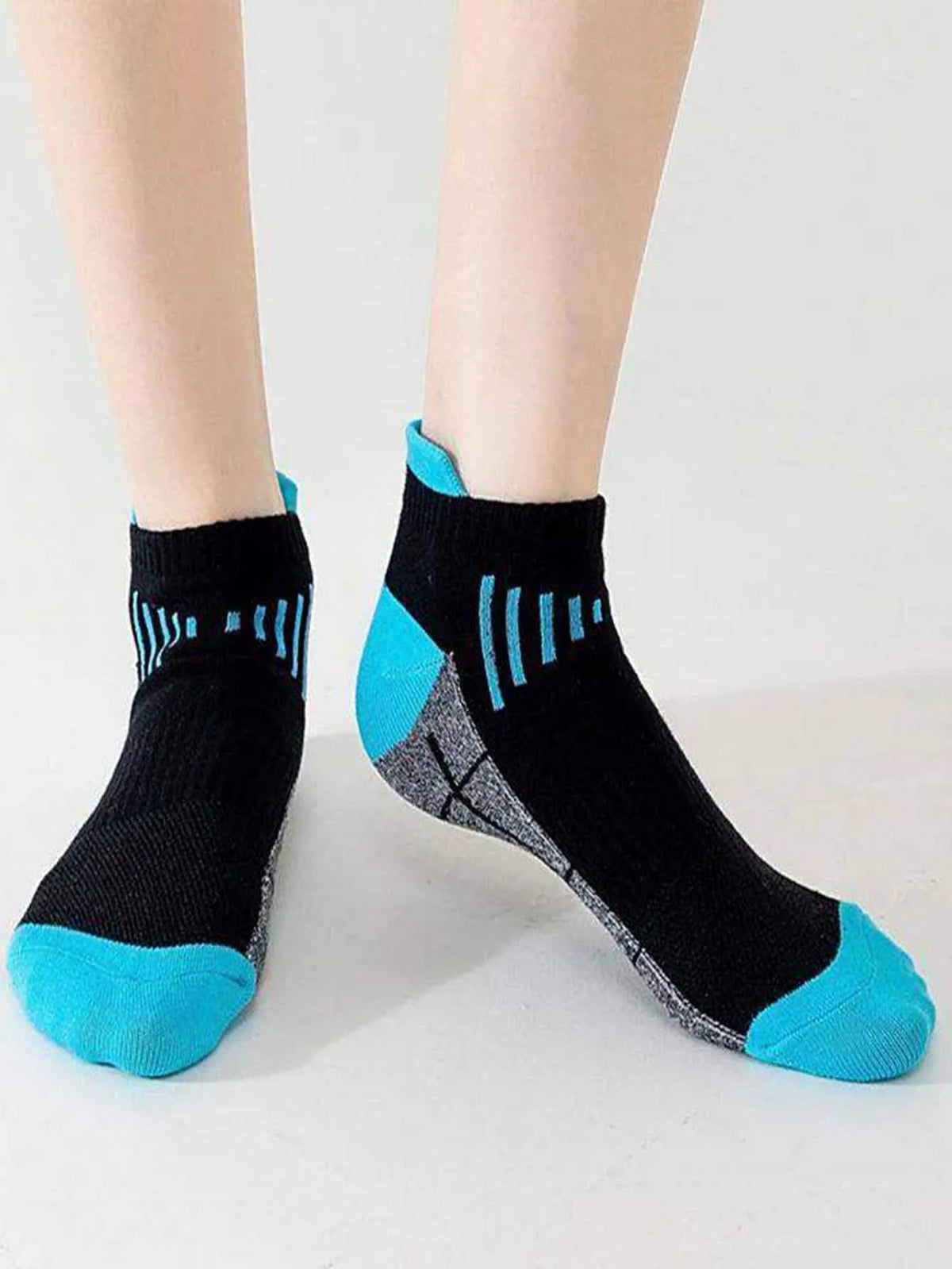Ein Paar schwarze, feuchtigkeitsableitende Sportsocken mit leuchtblauen Akzenten und Streifenmuster.