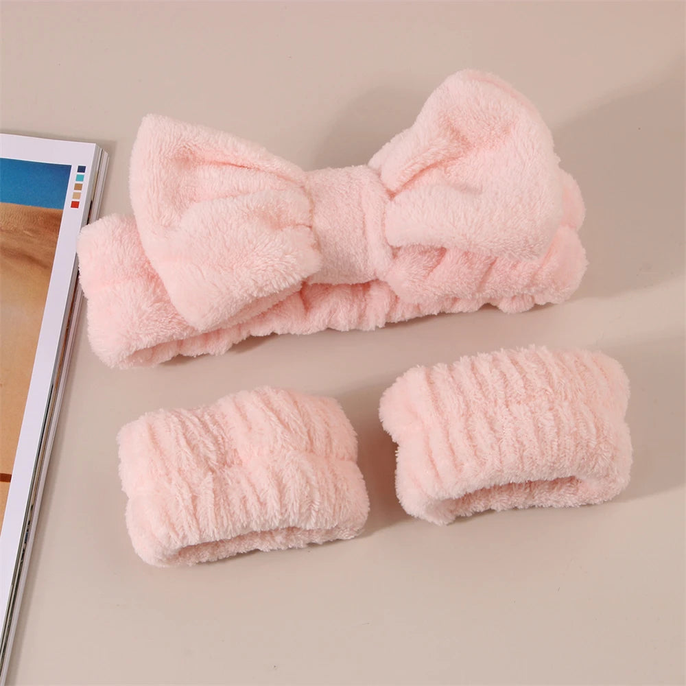 A set of pink microfiber spa headband and wristbands displayed on a light background.