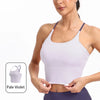 A woman models a light purple summer strappy yoga sports bra with built-in padding.