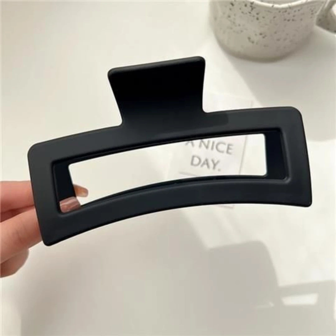 A black matte claw clip is shown against a white background.