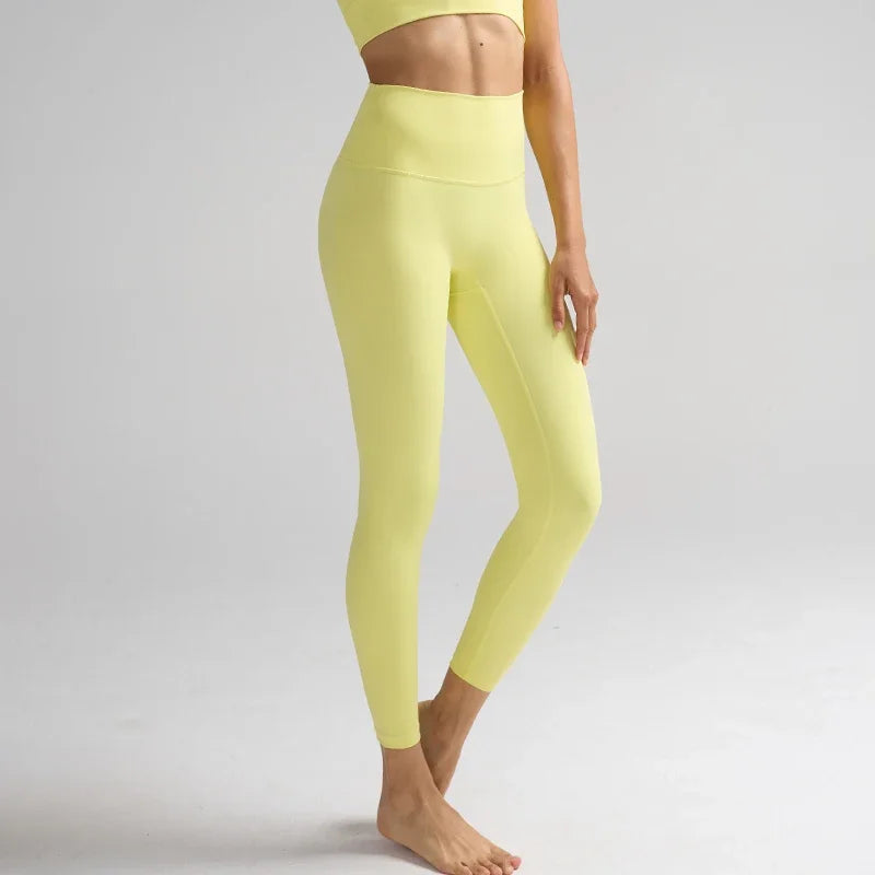 Une femme portant des leggings de performance à taille haute jaune vif.