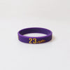 A purple silicone wristband with the number 23 engraved on it.