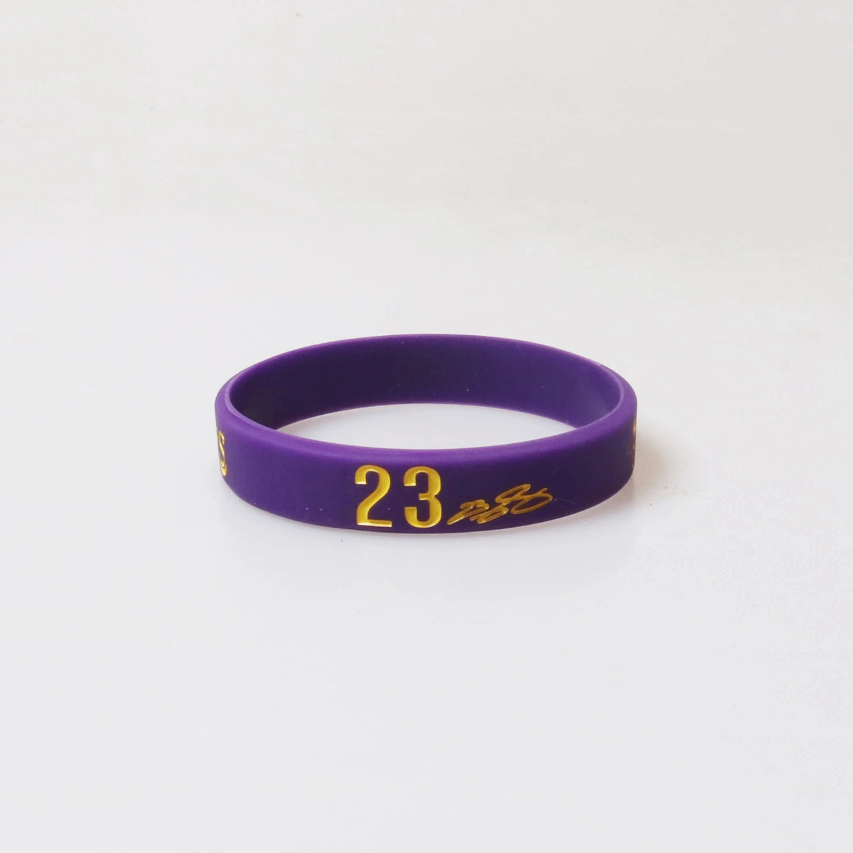A purple silicone wristband with the number 23 engraved on it.
