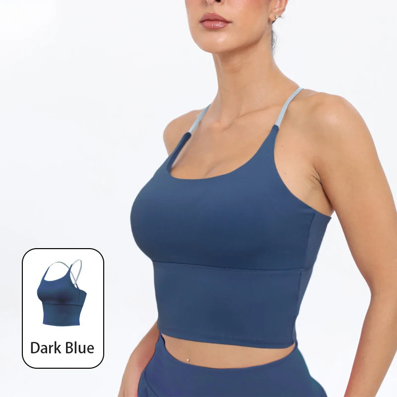 A model wearing a dark blue summer strappy yoga sports bra with built-in padding.