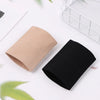 Manche de compression beige et noir pour le poignet, posé sur une surface blanche.