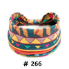 A colorful boho cotton turban headband featuring geometric patterns in teal, orange, yellow, and pink.