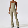 A woman wearing a beige women's performance tracksuit set, including a tank top and matching pants.