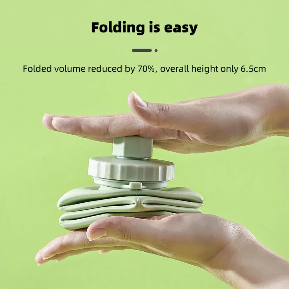 Hands are folding a light green silicone water bottle, demonstrating its easy folding feature.