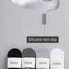A set of white silicone non-slip no-show socks displayed next to a bare foot.